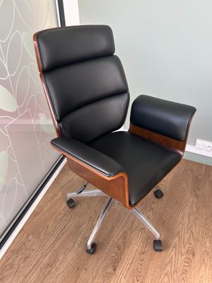une chaise de bureau noire posée devant un mur