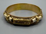 une photo d'un bracelet en or orné de perles blanches