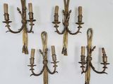 four antique brass wall sconces on a white background
