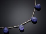 a close up of a necklace with blue beads on a black background