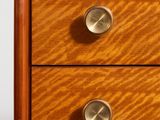 a close up of a wooden dresser with three drawers