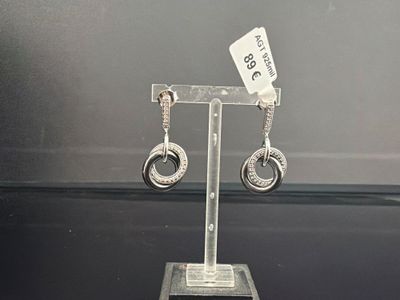 une paire de boucles d'oreilles exposées sur un présentoir
