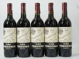 six bottles of wine are lined up on a white surface