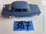 une petite voiture bleue posée sur une feuille de papier bleue