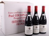 trois bouteilles de vin rouge devant une boîte blanche