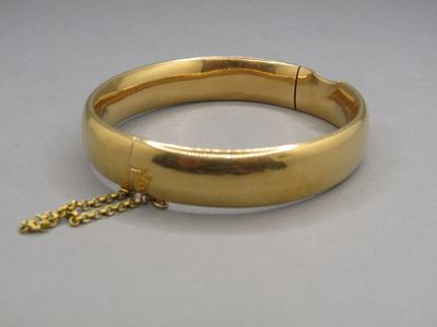 une image montrant un gros plan d'un bracelet en or muni d'une chaîne