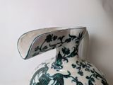 a green and white vase sitting on a table