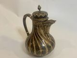 an antique silver plated coffee pot on a white background
