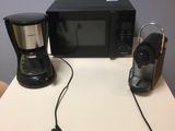 un micro-ondes et une cafetière posés sur une table