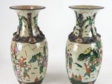 pair of chinese vases with oriental designs on them on a white background