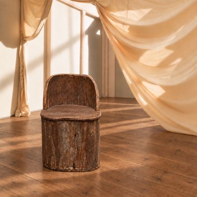 une chaise placée devant un rideau