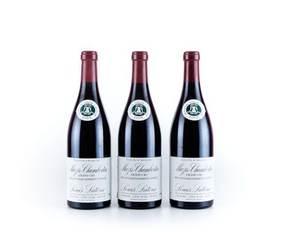 trois bouteilles de vin rouge posées l'une à côté de l'autre sur une surface blanche