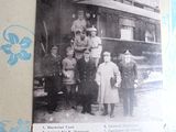 une vieille photo montrant un groupe de personnes debout devant un train