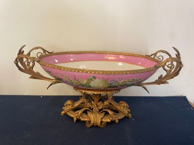 a pink and gold bowl sitting on a blue table