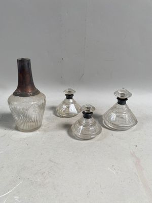 trois vases en verre et une bouteille posés sur une table