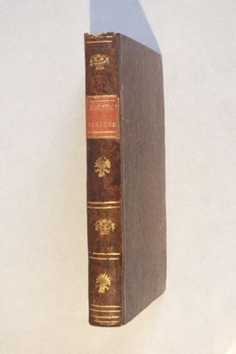 un livre marron posé sur une table blanche