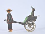 a toy of a man pulling a cart with a woman on it