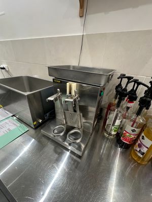 un plan de travail en acier inoxydable dans une cuisine professionnelle, sur lequel sont posées de nombreuses bouteilles