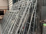 a pile of metal ladders stacked up in a warehouse