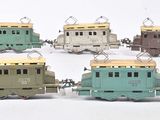plusieurs petits trains sont alignés sur une surface blanche