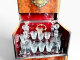 bottles and glasses in a wooden case on a white background