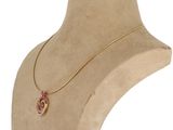 necklace on a mannequin neck with a gold chain and a pendant with a pink stone