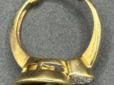 an image of a gold ring with a diamond in the middle
