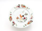 une assiette blanche décorée d'un coq et de fleurs