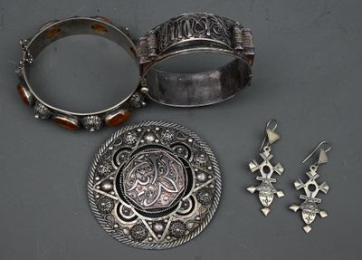 deux bijoux en argent posés sur une table