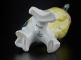 a small figurine of a horse with a yellow apple in the background