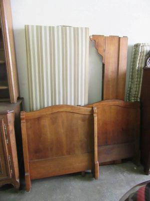 un lit avec une tête de lit en bois et une commode dans un coin