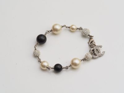 a close up of a bracelet with pearls and charms on it