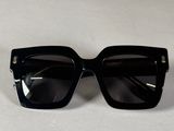 une paire de lunettes de soleil noires posée sur une table blanche
