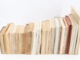 many books stacked on top of each other on a table