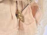 a close up of a doll wearing a dress and a hat
