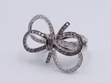 silver bow ring with black and white diamonds on a white background