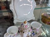 une vitrine en verre sur laquelle est posé un service à thé