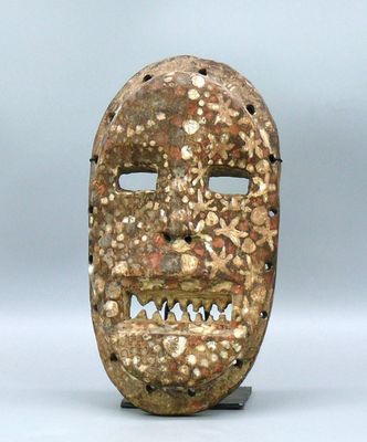 gros plan d'un masque en bois sur une surface blanche