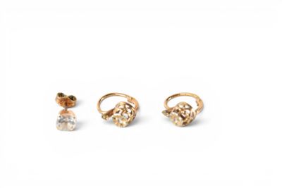 three pairs of gold earrings and a ring on a white background