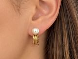 un gros plan sur une femme portant une paire de boucles d'oreilles en perles