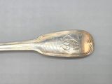 silver spoon with a face on it sitting on a gray surface