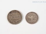 two coins sitting side by side on top of a white surface