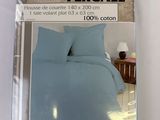l'emballage d'un lit avec une couette bleue et des oreillers