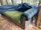 un canapé recouvert d'une couverture, installé sur une terrasse