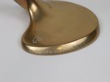 a gold golf putter that is sitting on a white table