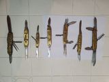 many different types of knives hanging on a wall