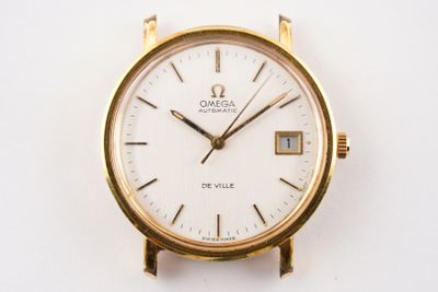 a gold watch with a white face on a white surface