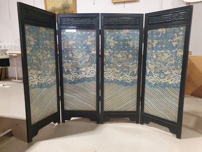 four paneled screen with oriental designs on it in a room
