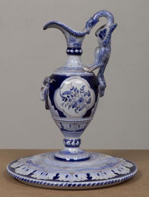 un vase bleu et blanc orné d'une tête de bélier