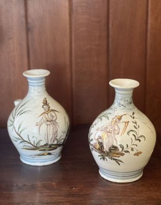 deux vases posés sur une table, avec en arrière-plan un mur lambrissé